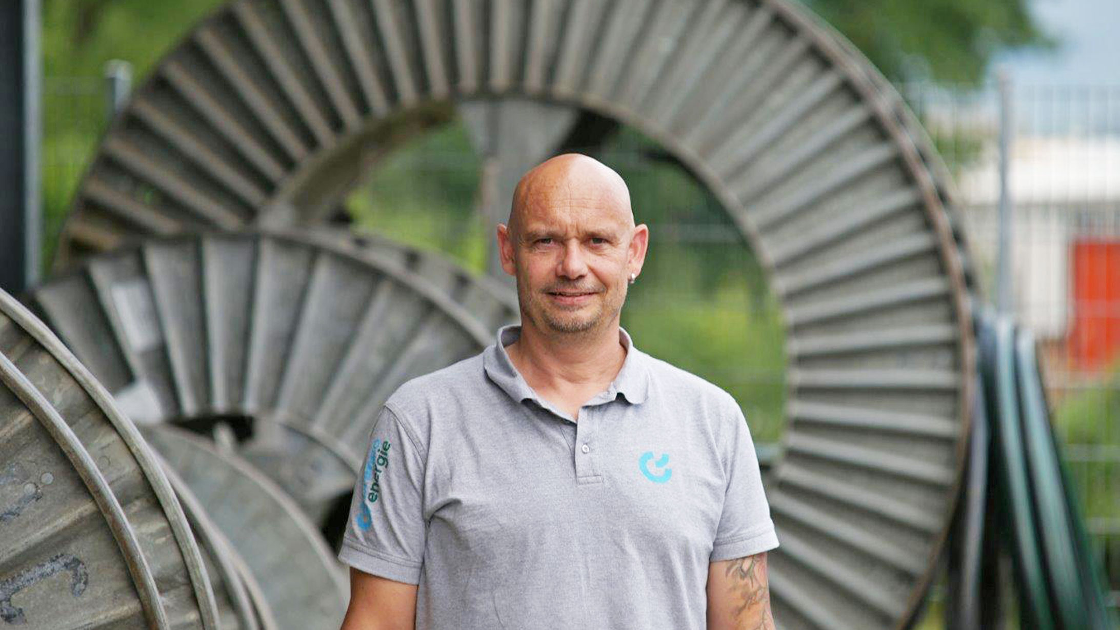 Thomas Kohler, Lernendenbetreuer bei Primeo Energie, steht vor einer grossen Kabelrolle.