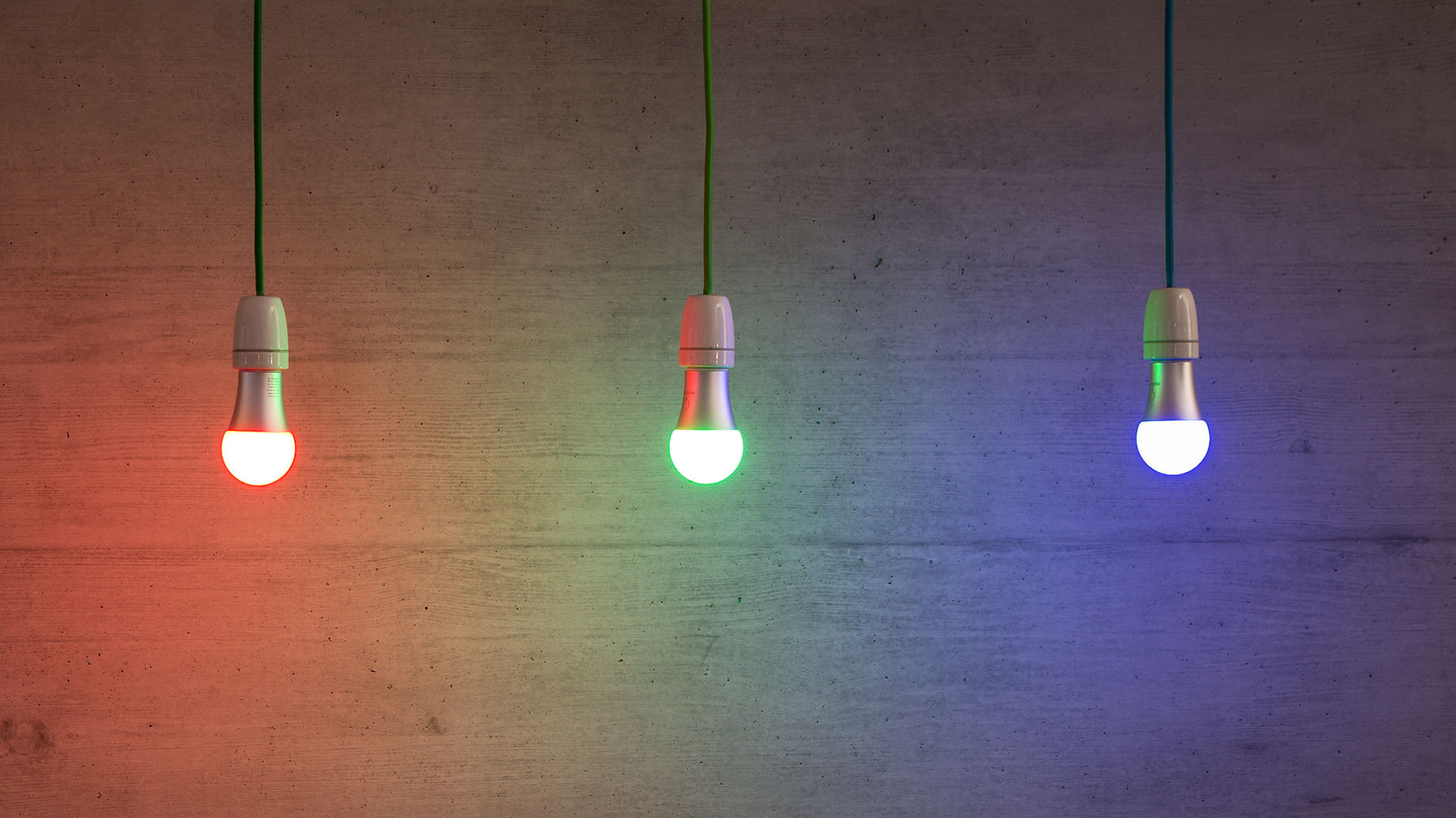 Smart Home: drei aufgehängte Glühbirnen in rot, grün und blauer Farbe