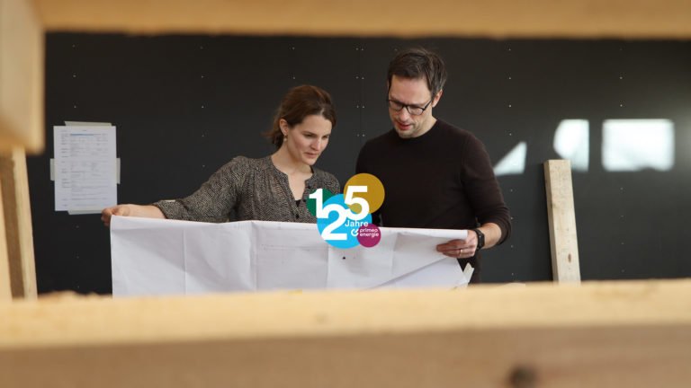 Wolfgang Szabó und Corinne Gasser, die Leiter des Primeo Energie Kosmos, betrachten einen Plan.