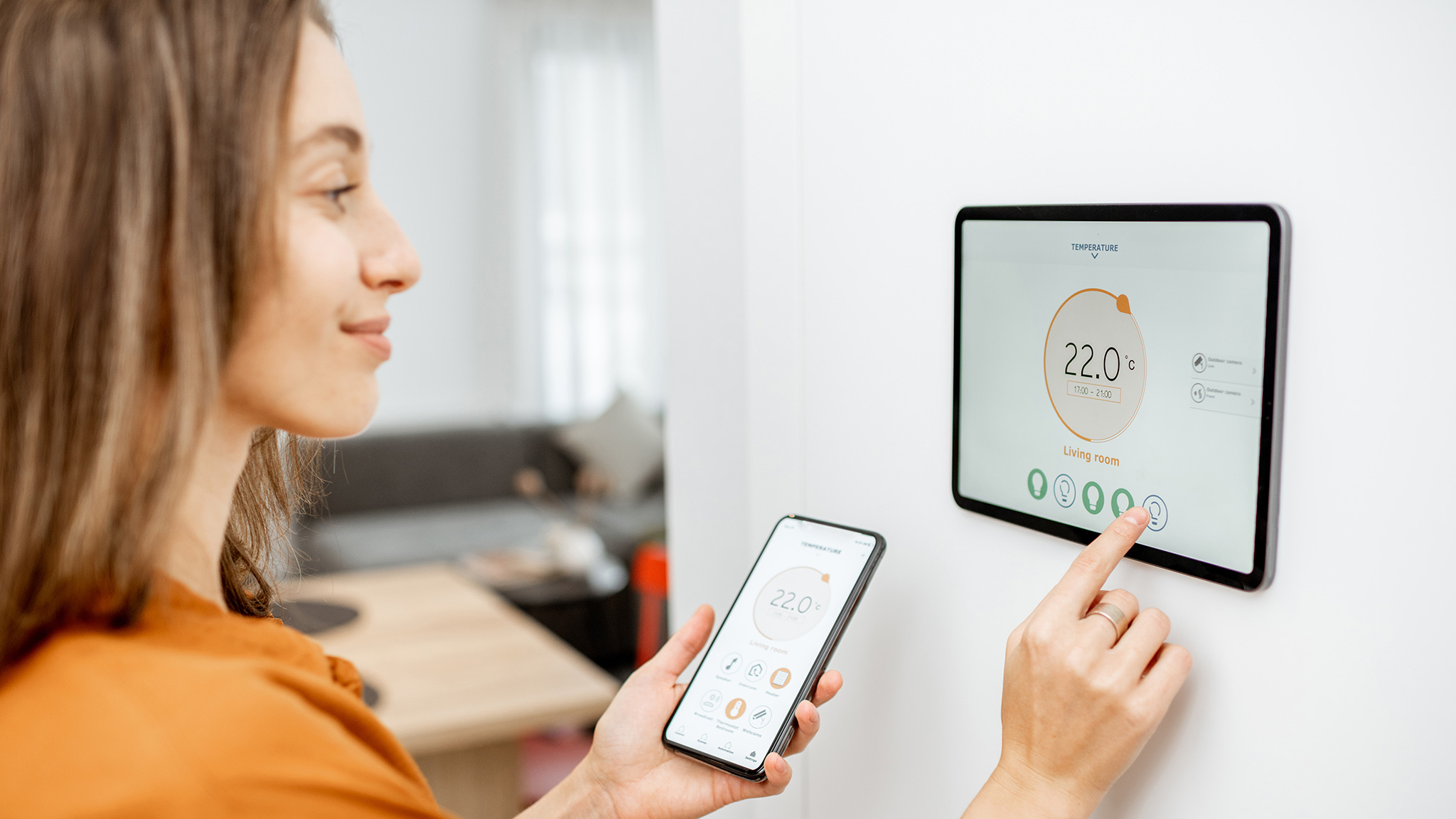 Frau stellt Temperatur an Smart Home Panel ein
