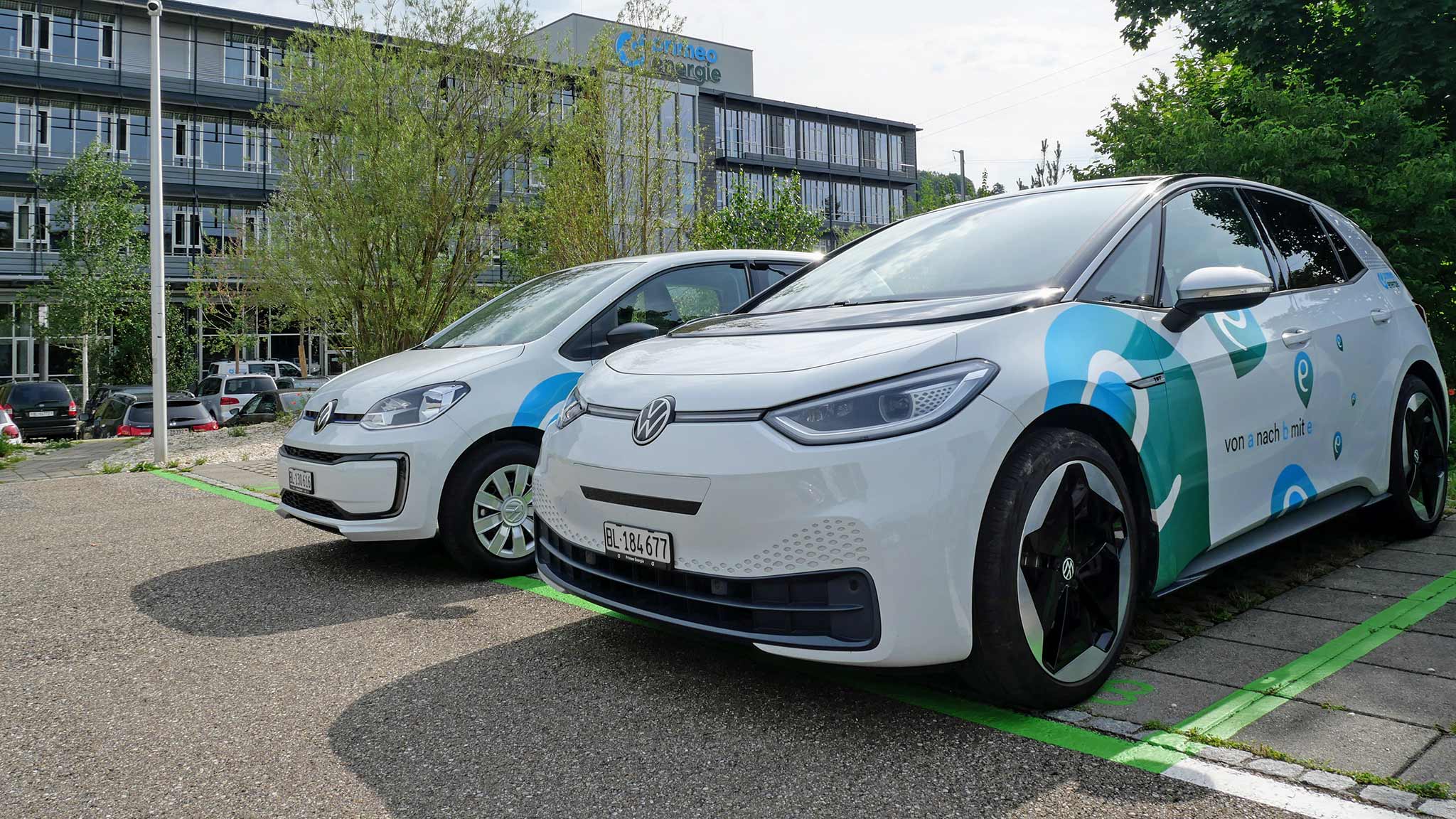 Zwei Elektroautos von VW stehen vor dem Hauptsitz von Primeo Energie in Münchenstein