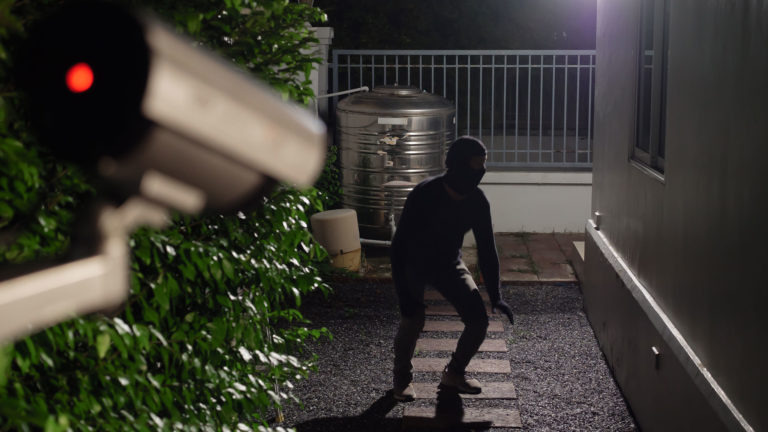 Einbrecher vor einem Haus wird von Überwachungskamera gefilmt